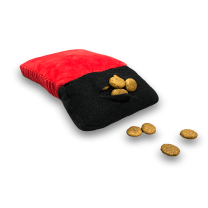 red calculator plush dog toy with a treat pocket filled with dog food.