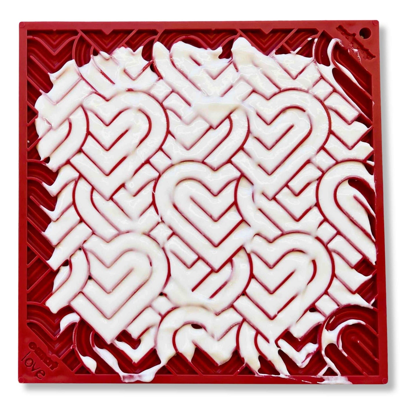 Red heart design enrichment lick mat for dogs with greek yoghurt spread on it's surface.